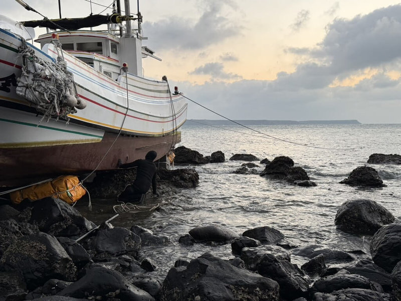 澎湖籍漁船雙全利號5日疑因機械故障失去動力，擱淺在馬公青灣南海域礁岩區，救難協會協助船體定錨，並架設保麗龍浮具防護，將待午夜漲潮時段由其他船隻拖帶，盼能順利脫困。（澎湖消防局提供）中央社　115年1月5日