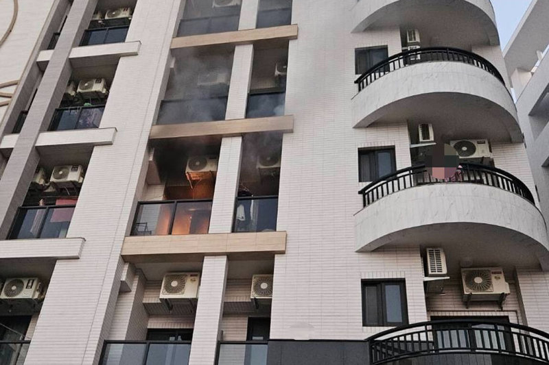 台南市新市區潭頂里一間7層樓住宅建物3樓處5日上午發生火警，屋內3人逃到陽台處待援，由消防人員協助撤離。（讀者提供）中央社記者楊思瑞台南傳真　115年1月5日