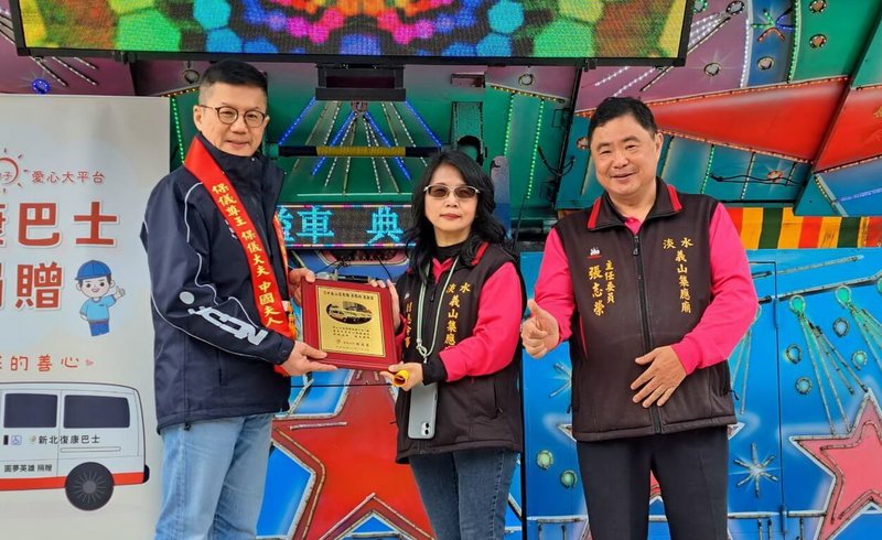 新北市淡水義山集應廟志工詹淑媚（中）8日捐贈復康巴士給新北市府，累計已捐贈4輛，市府副秘書長張其強（左）代表市長侯友宜回贈感謝牌給詹淑媚。圖右為集應廟主委張志榮。（新北市府社會局提供）中央社記者黃旭昇新北市傳真　115年1月8日