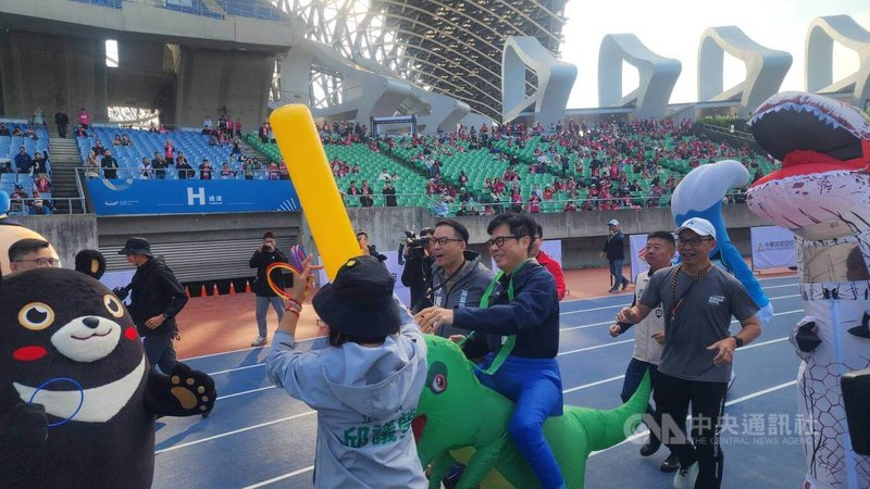 2026高雄富邦馬拉松16週年10日開跑，市長陳其邁（前右2）與3名角逐市長初選參選人共同出席。陳其邁上午穿恐龍裝參加接力競賽更恰好「交棒」給立委邱議瑩（前左2），場面溫馨熱鬧。中央社記者洪學廣攝　115年1月10日