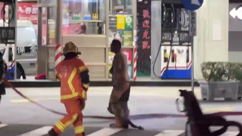 新北市板橋區民族路加油站9日晚間發生民眾點火,引發火警並波及正在加油的保全員事件。警方10日表示,犯嫌一度追打消防隊員,消防員已提出傷害與妨害公務罪告訴;圖為犯嫌點火後,仍在加油站內遊走,引發民眾恐慌。(徐姓民眾提供)中央社記者黃旭昇新北傳真 115年1月10日