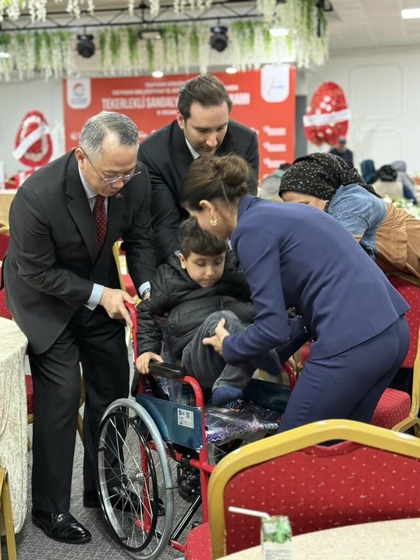 駐土耳其代表黃志揚（左）9日代表台灣，捐贈315台輪椅給土耳其南部阿達那（Adana）的身障兒童使用。圖為黃志揚等人協助身障兒童坐上輪椅。（駐土耳其代表處提供）中央社記者李晉緯新德里傳真　115年1月10日
