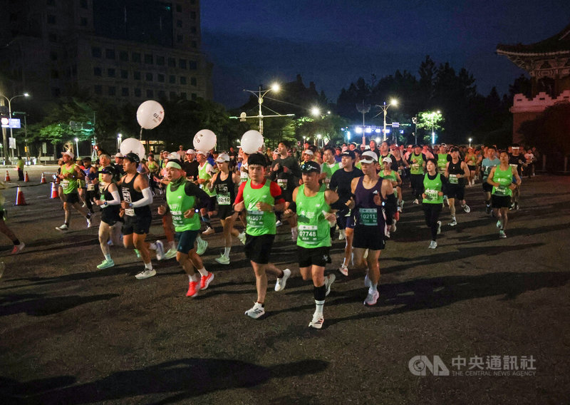2026渣打台北公益馬拉松11日上午5點半在總統府前凱達格蘭大道起跑，全馬跑者在夜色中出發，大批跑者依序跑出，繞行一圈中正紀念堂後跑向中山南路往河濱公園邁進，配速員（汽球者）帶著跑者穩定跑向終點。中央社記者張新偉攝 115年1月11日