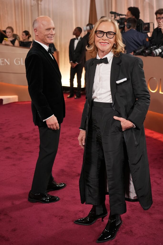 憑「凶器」入圍最佳女配角艾美麥蒂根（右）身穿長版西裝外套氣勢十足，她與丈夫艾德哈里斯（Ed Harris）一同出席。（美聯社）