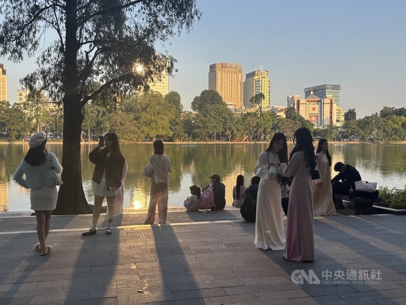 春節將近，走在越南首都河內的觀光景點還劍湖，最顯眼的存在，就是一群群身穿各色奧黛的越南少女，為了在社群媒體上分享美照而努力，令這些拍照女孩成了和湖光爭寵的風景線。中央社記者曾婷瑄河內攝　115年1月14日