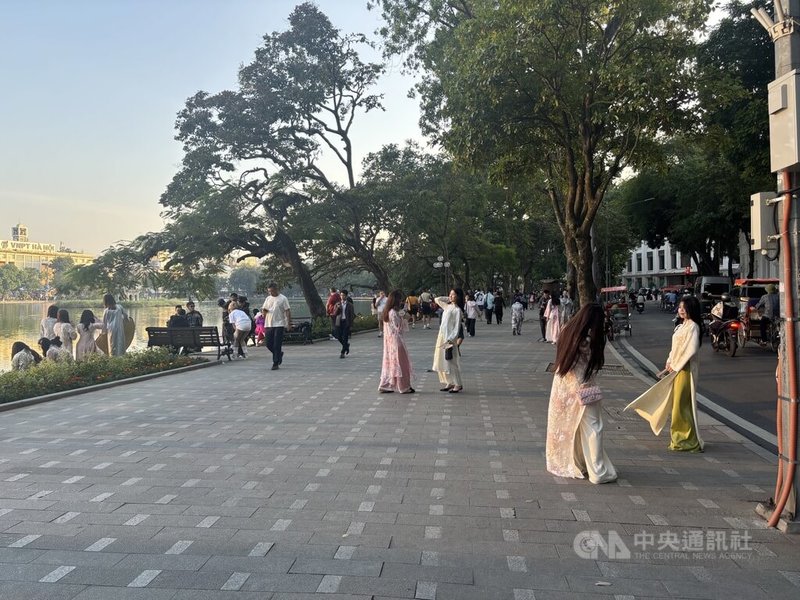 越南人對於拍照的認真程度絕不開玩笑。街邊景點總可見帶著腳架、相機，甚至反光板，手持特別買的蓮花、雛菊等花卉的年輕人。他們秉持「文化遺產炫耀運動」 ：越傳統，越時髦。中央社記者曾婷瑄河內攝　115年1月14日