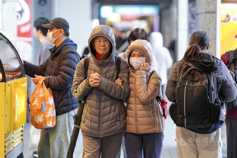 圖為北市街頭行人穿著外套、拉起帽子，全身包緊緊禦寒。（中央社檔案照片）