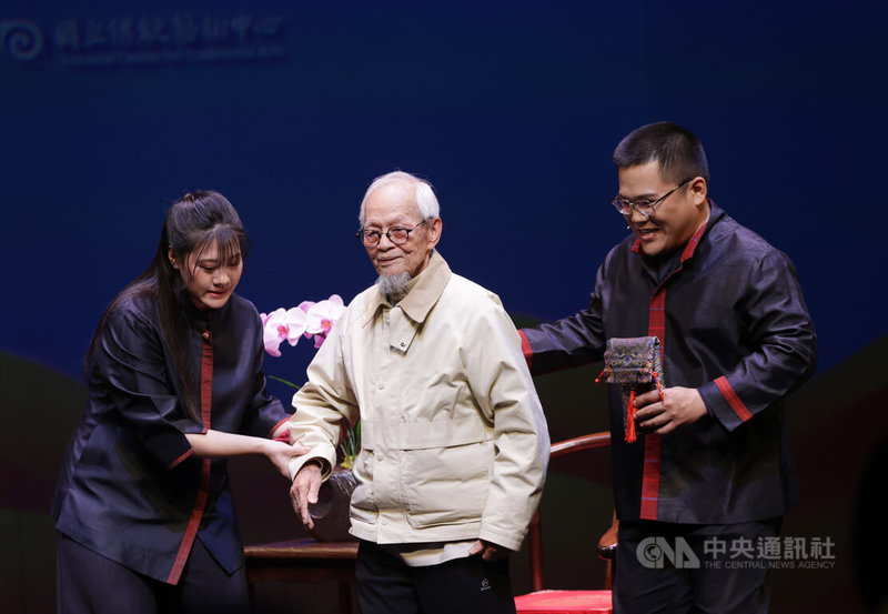 「傳統藝術接班人–駐團演訓計畫」15日在台灣戲曲中心舉行第4屆結業授證典禮暨謝師禮，台北木偶劇團習藝生林宸弘（右）、劉士聞（左）向授業教師、北管音樂保存者邱火榮（中）行謝師禮，表達對教師誨人不倦的感謝。中央社記者裴禛攝 115年1月15日