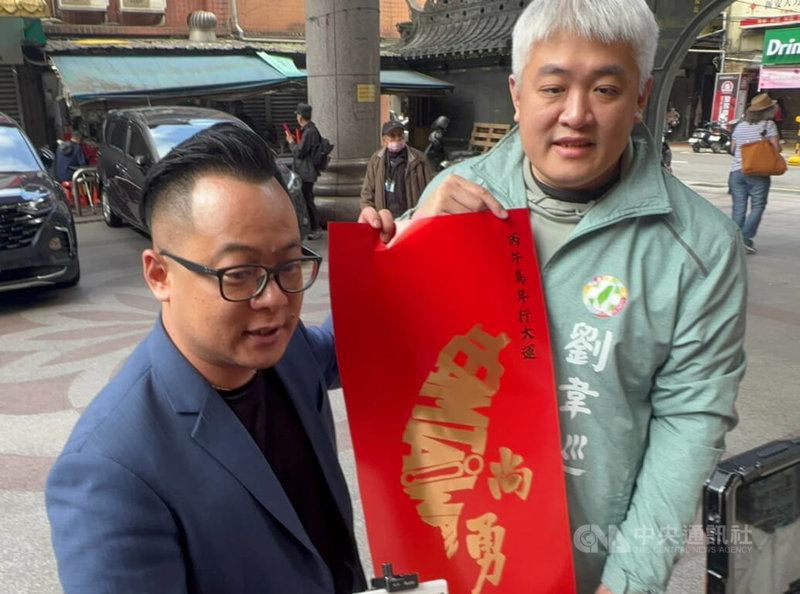 民進黨基隆市長提名人、議長童子瑋（前左）18日在慶安宮前廣場發送「台灣尚勇」春聯，邀請鄉請用尚勇的氣勢迎接新春。中央社記者王朝鈺攝　115年1月18日
