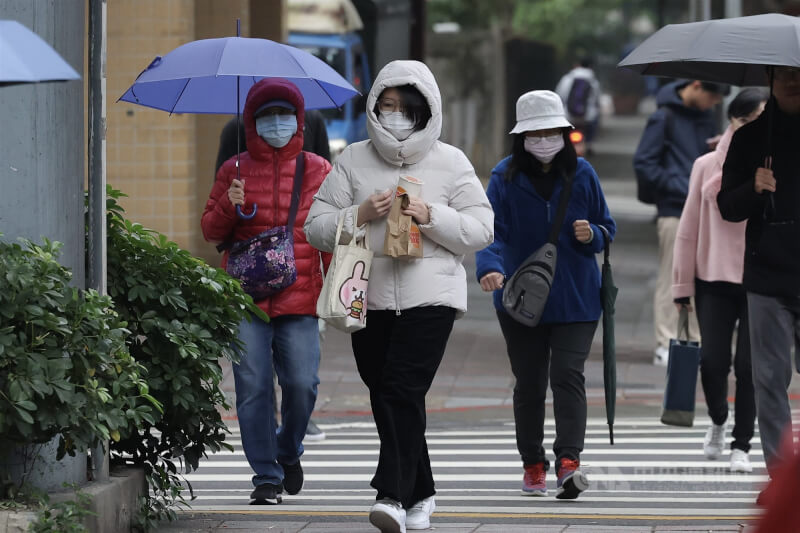 圖為台北市大安區民眾穿羽絨衣並戴口罩保暖。（中央社檔案照片）