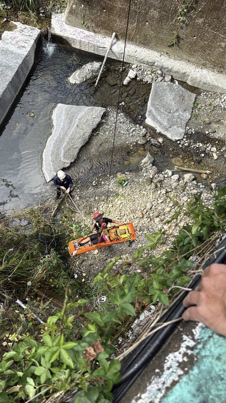 南投魚池鄉18日上午一名青少年騎乘自行車行經大林橋時，不慎掉落約12公尺深河谷，消防隊員在橋上架設繩索，垂降進入河谷，將其安全吊掛至路面送醫。（南投消防局提供）中央社記者吳哲豪傳真　115年1月18日