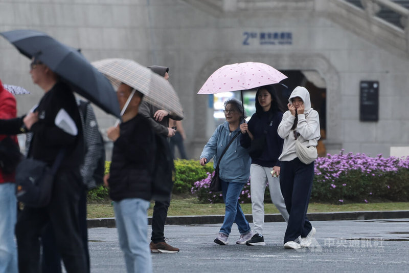 中央氣象署表示，19日起東北季風增強，迎風面的北部與東半部有下雨機會，晚間強烈大陸冷氣團報到，各地溫度將逐漸下降。台北市區下午刮起陣風、細雨，在中正紀念堂旅遊的民眾用外套蓋住頭部遮風避雨。中央社記者裴禛攝 115年1月19日