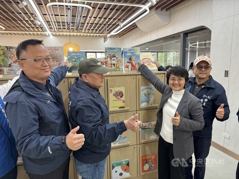 雲林縣崙背鄉公所21日舉辦新圖書館啟用典禮，以人力傳書方式，將上萬本書籍從舊圖書館搬遷到新址，最後由客委會主委古秀妃（右2）、崙背鄉長李泓儀（右1）和台塑企業麥管部副總經理蔡建樑（左1）等人將書籍上架。中央社記者姜宜菁攝　115年1月21日