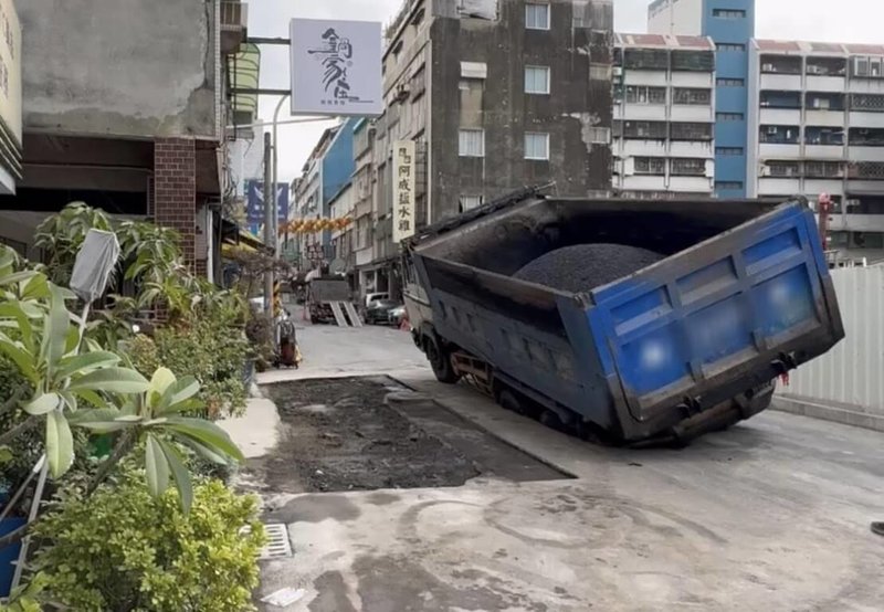 台南市中西區五妃街接近西門路口20日下午發生路面下陷，出現一個巨大坑洞，市府回填灌漿後，未料21日又發生塌陷，造成1輛砂石車陷入路面。（讀者提供）中央社記者張榮祥台南傳真　115年1月21日