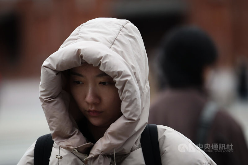 氣象署21日發布北北基等10縣市低溫特報，清晨本島平地最低溫為雲林縣古坑鄉攝氏8.9度。圖為台北市萬華區行人將外套帽子戴起來防風禦寒。中央社記者吳家昇攝　115年1月21日