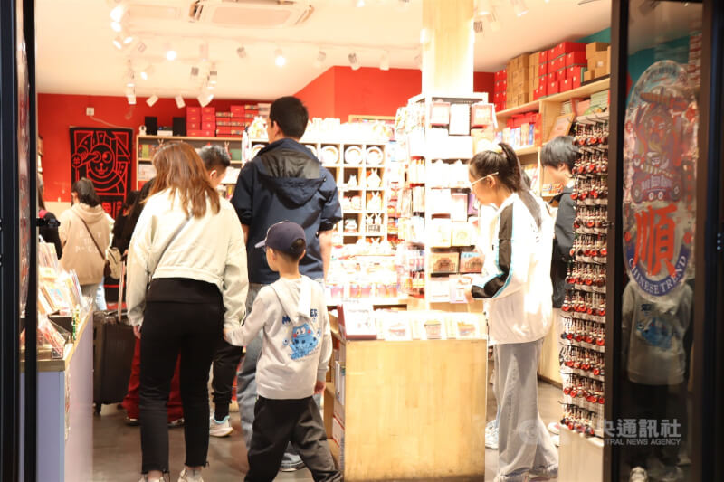 學者梁中堂認為中國實際的生育率比韓國還低。圖為家長帶著孩子逛北京一間紀念品商店。（中央社檔案照片）