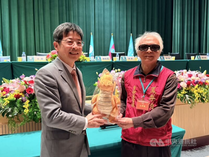 玉山金23日舉行115年第一次股東臨時會,股東致贈「快龍」玩偶祝福玉山金控業績長紅。圖為玉山金董事長黃男州(左)。中央社記者呂晏慈攝 115年1月23日