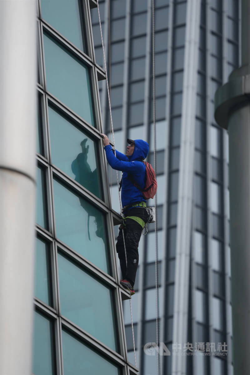 21日上午台北市信義區濕冷飄雨，美國自由攀岩好手霍諾德在有安全繩及保護裝備下進行試爬。（中央社檔案照片）