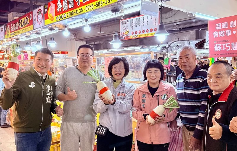 民進黨新北市長被提名人、立委蘇巧慧（左3）24日前往泰山區公有市場拜票，有攤商送上寓意好彩頭的菜頭祝福她。（蘇巧慧辦公室提供）中央社記者黃旭昇傳真　115年1月24日