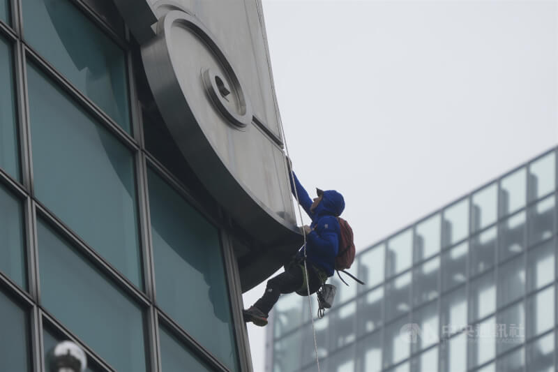 圖為美國自由攀岩好手霍諾德21日上午在101大樓刁鑽的角度進行雨天試爬。（中央社檔案照片）