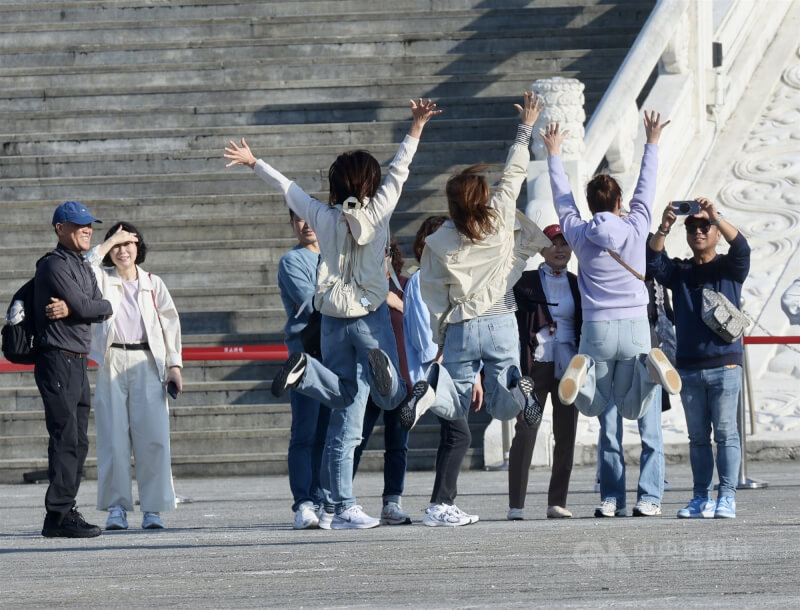 圖為許多遊客趁著好天氣造訪台北市中正紀念堂，開心躍起拍照留影。（中央社檔案照片）