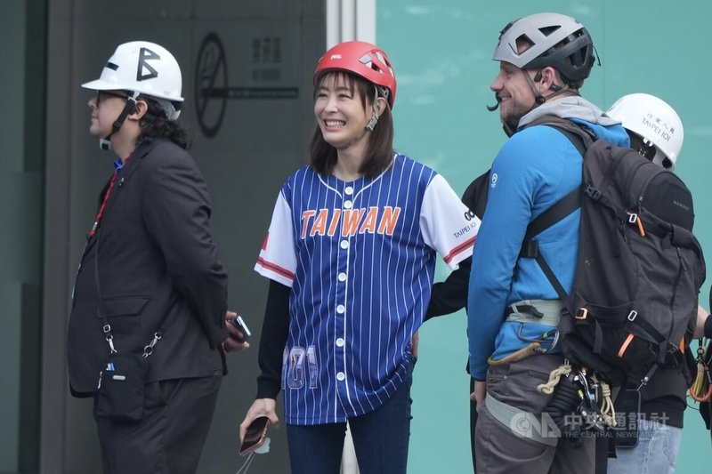 美國自由攀岩好手霍諾德（Alex Honnold）25日耗時約91分鐘，順利赤手完攀台北101，成為全球第一人。台北101董事長賈永婕（中）透露，特別將台北101外5根高聳旗桿上的旗幟全數換成中華民國國旗，「怎麼樣都可以拍得到，怎麼樣全世界都看得到」。中央社記者徐肇昌攝　115年1月25日