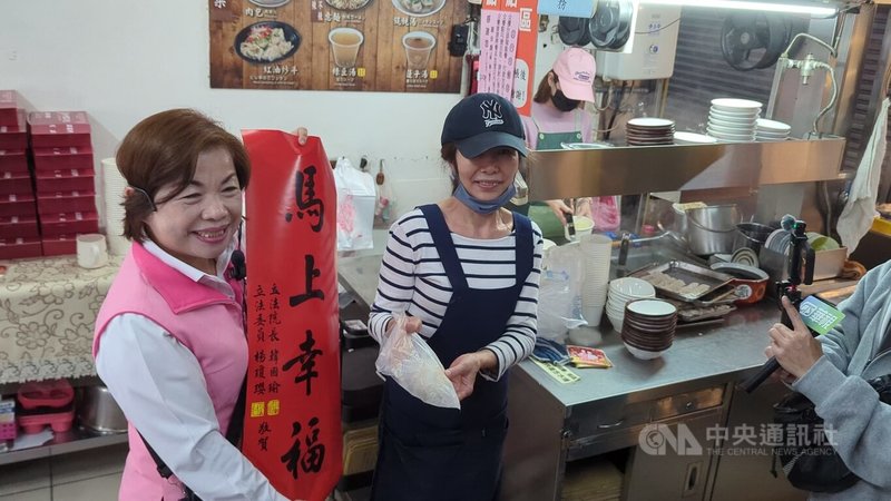 中國國民黨台中市長提名人選未定，爭取提名的立委楊瓊瓔（左），25日前往中區第二市場掃街發送春聯，有支持者送上包子大喊加油等口號。中央社記者蘇木春攝　115年1月25日