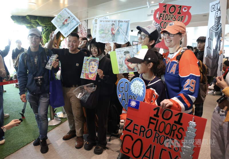 許多民眾手舉看板在台北101大樓89樓觀景台為他加油打氣。中央社記者張新偉攝　115年1月25日