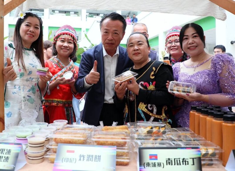 嘉義縣政府26日在縣府中庭舉辦「2026台灣燈會—新住民燈區」宣傳記者會。與會的新住民向縣長翁章梁（右3）介紹家鄉的美食。（嘉義縣政府提供）中央社記者黃國芳傳真　115年1月26日