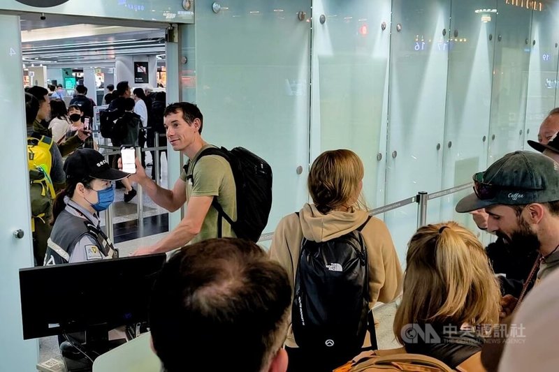 美國自由攀岩好手霍諾德（Alex Honnold）（左2）在成功攻頂台北101後，26日早上搭機離台，霍諾德未受訪，許多搭機民眾看見霍諾德紛紛搶著和他合照，還有旅客對著他高喊Hero。中央社記者吳睿騏桃園機場攝　115年1月26日