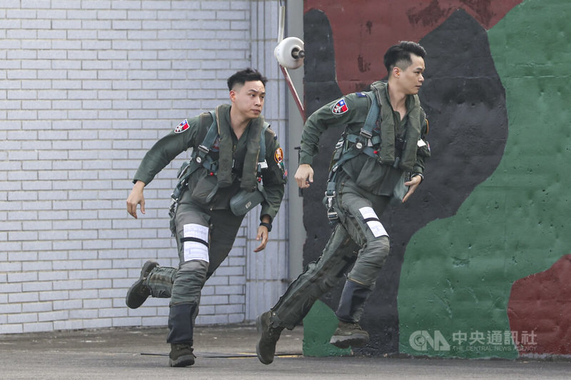 國防部27日舉行民國115年國軍春節加強戰備媒體邀訪活動，空軍模擬警戒期間飛行員全副武裝穿戴抗G衣、求生背心及軀幹吊帶隨時待命，警鈴響起後，從警戒室以最快速度到達F-16機庫出勤。中央社記者鄭清元攝　115年1月27日