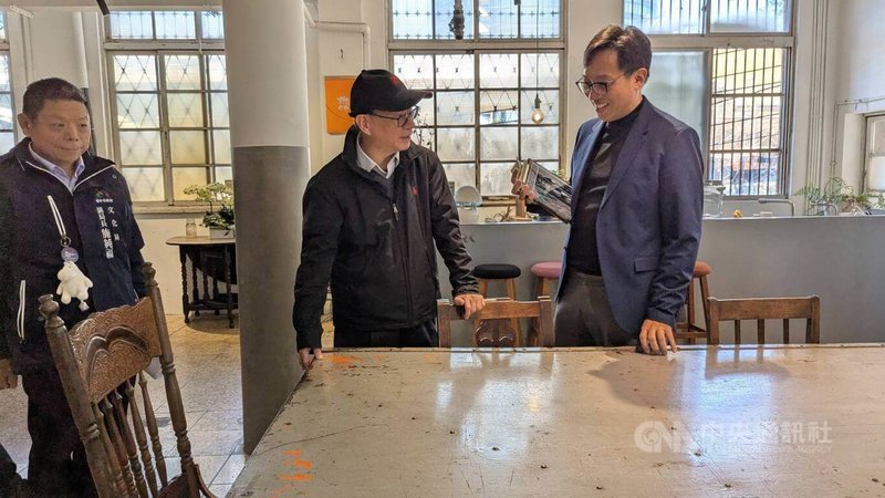 富興工廠1962創辦人許清皓(右),向文化部長李遠(中)介紹富興工廠1962運用舊工廠鐵門改製桌子。中央社記者王寶兒攝 115年1月28日