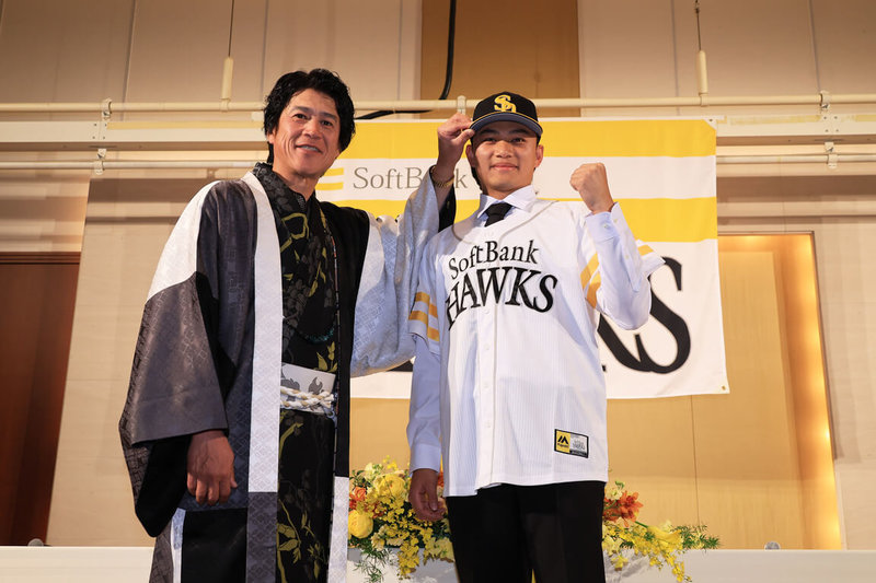 台灣投手徐若熙（右）29日在日本出席日職福岡軟銀鷹隊舉辦的加盟記者會，會中並由軟銀鷹隊首席棒球總管（CBO）城島健司（左）為他戴上球帽。（福岡軟銀鷹提供）中央社記者蘇志畬傳真　115年1月29日