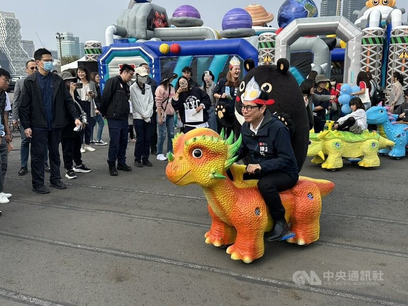 高雄市觀光局30日舉辦「2026 Kaohsiung Wonderland 高雄冬日遊樂園」記者會，市長陳其邁（前）體驗全新恐龍車設施，在園區中與小朋友「尬車」。中央社記者林巧璉攝　115年1月30日