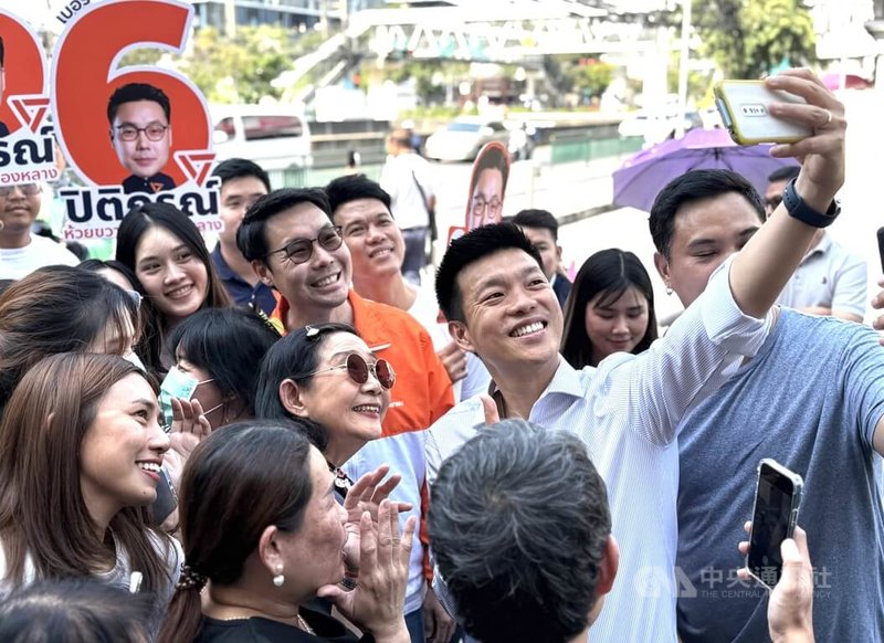 泰國2月8日舉行大選，最新民調顯示，被視為代表年輕世代及改革派的人民黨最受選民青睞，而該黨首席總理候選人納塔彭的支持率也以29.08%位居第一。圖為納塔彭28日在曼谷市場拜票，持手機與選民自拍。中央社記者李宗憲曼谷攝　115年1月30日