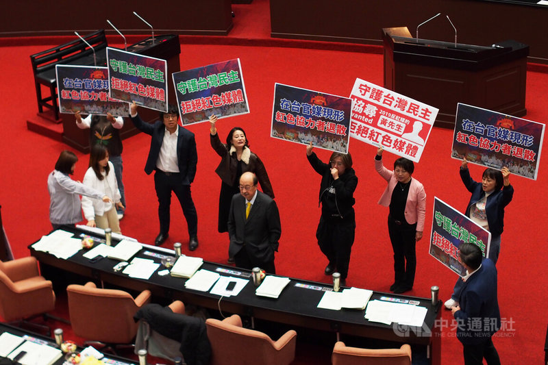 立法院30日院會處理被外界視為中天回復執照相關的衛星廣播電視法部分條文修正草案,民進黨團在場內高舉標語,表達「守護台灣民主、拒絕紅色媒體」立場。中央社記者趙世勳攝 115年1月30日