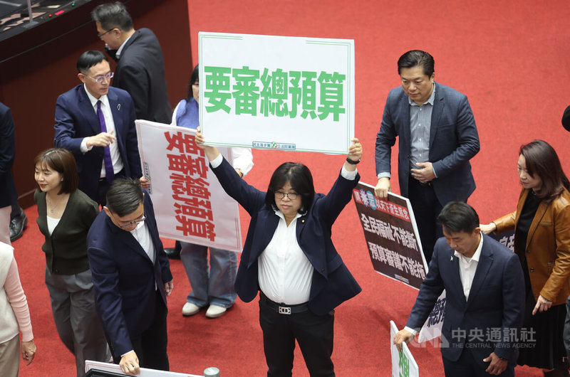 立法院會30日開會，處理報告事項時，藍白挾人數優勢通過其提議，將民眾黨團所提保衛國家安全及強化不對稱戰力計畫採購特別條例草案付委審查，另封殺行政院所提的8年新台幣1.25兆元的國防特別條例草案。圖為民進黨立委王美惠（中）在議場舉手板表達立場。中央社記者趙世勳攝　115年1月30日