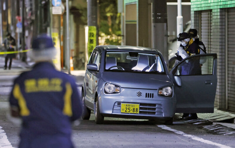 日本東京街頭發生搶案，現場附近一輛藍色輕型轎車遭歹徒棄置。（共同社）