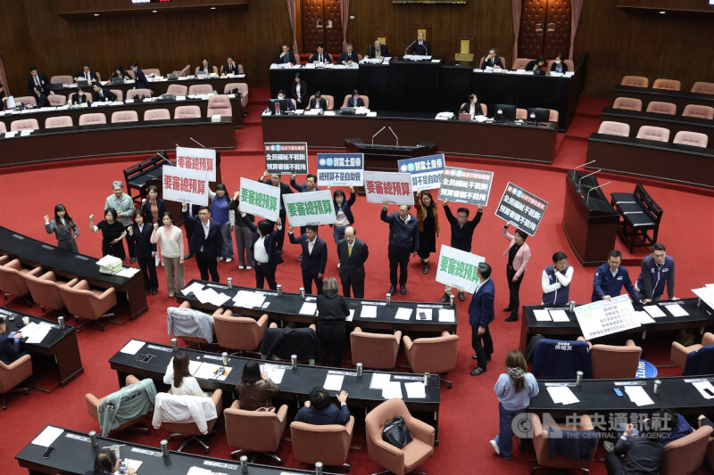 立法院會30日上午針對議事日程草案進行投票表決，民進黨立委在議場內舉手板，呼籲儘速審議總預算案、軍購特別條例等。中央社記者趙世勳攝　115年1月30日