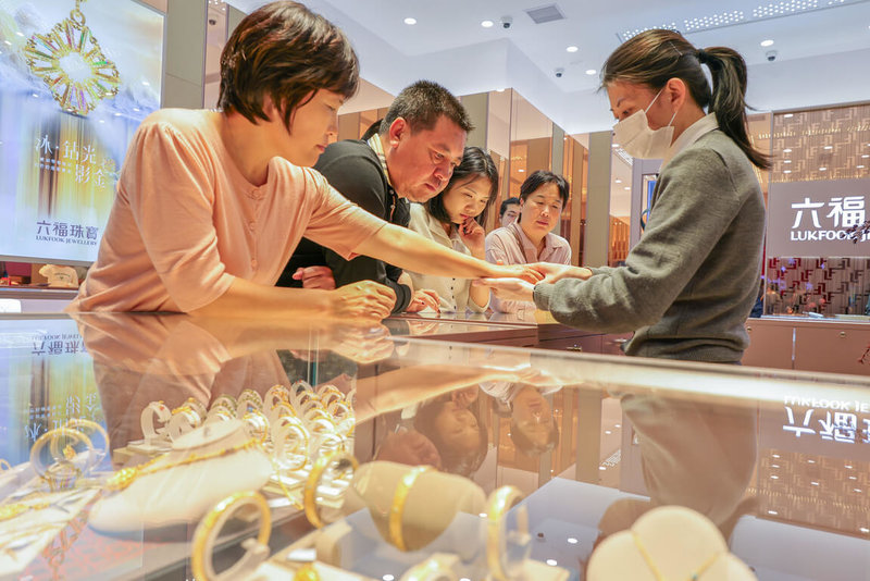 胡潤研究院30日發表報告指出，未來一年，中國富豪最傾向增持的資產是黃金和境外投資。圖為元旦，顧客在cdf海口國際免稅城選購黃金飾品。（中新社提供）中央社　115年1月31日