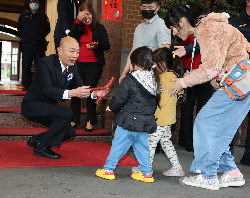 「馬上幸福特別版限量春聯發送見面會」31日在立法院正門舉行,立法院長韓國瑜(前左)親自發送春聯給排隊領取的民眾,還特別蹲下身跟小朋友互動。中央社記者謝佳璋攝 115年1月31日