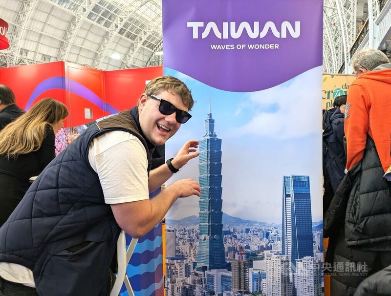 台灣參加英國規模最大年度消費者旅展之一「倫敦旅展」，今年緊扣美國自由攀岩好手霍諾德赤手登頂台北101國際話題，規劃系列活動，部分民眾熱情與台北101主題立牌合影。中央社記者陳韻聿倫敦攝　115年2月1日