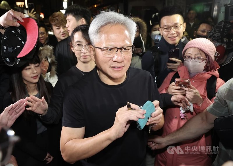 輝達（NVIDIA）執行長黃仁勳（前中）即將離台，1日晚間與台積電董事長暨總裁魏哲家等高層在台北鄒記食舖聚餐後，為守候在外的民眾簽名，親和力十足。中央社記者張新偉攝　115年2月1日