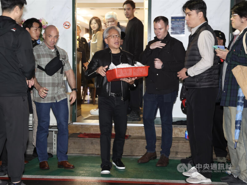 輝達（NVIDIA）執行長黃仁勳（前中）1日傍晚在台北鄒記食舖與台積電董事長暨總裁魏哲家等高層餐敘，兩度到門口發送紅豆餅給媒體與民眾。中央社記者張新偉攝　115年2月1日