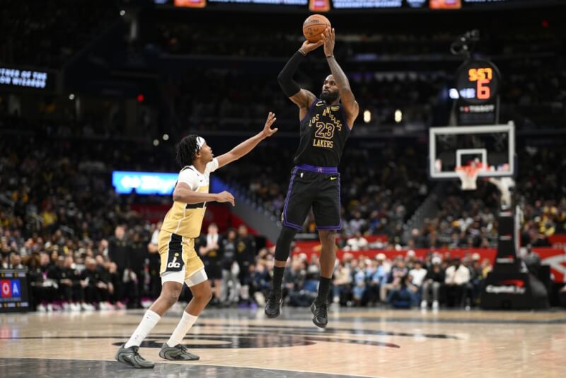 NBA湖人隊球星詹姆斯（右）1月30日在面對巫師隊比賽中跳投。（美聯社）