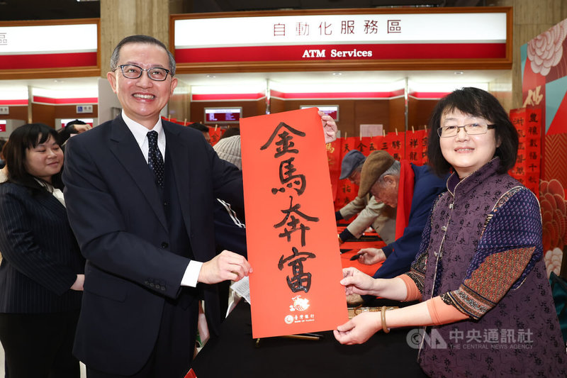 台灣銀行貴金屬部經理楊天立（前左）2日在台銀總部出席「墨香迎春賀新年」記者會。圖為楊天立與台灣女書法家學會理事長連瑞芬（前右）一同展示「金馬奔富」春聯。中央社記者王騰毅攝 115年2月2日