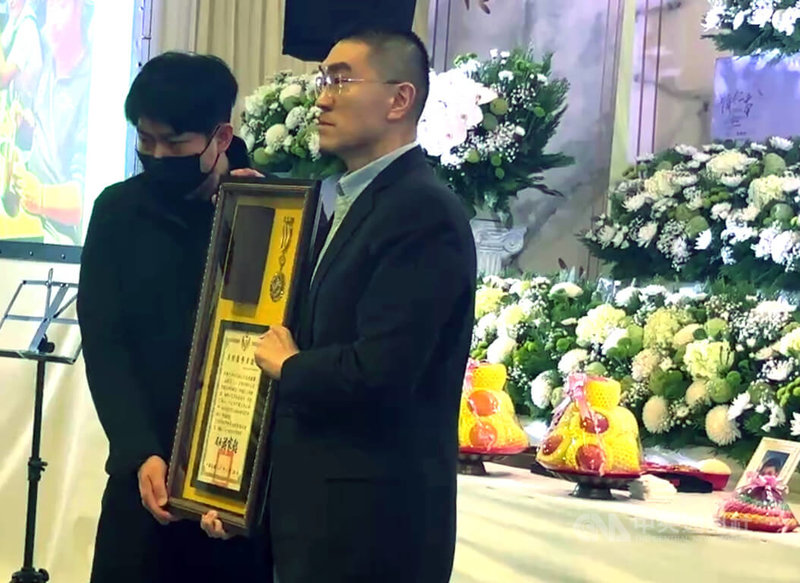 基隆市消防局仁愛消防分隊小隊長詹能傑在火場捨身救人殉職,家屬3日舉行公祭,基隆市長謝國樑(右)頒發追晉分隊長令及獎章,由弟弟詹庭豪(左)代表接受。中央社記者王朝鈺攝 115年2月3日