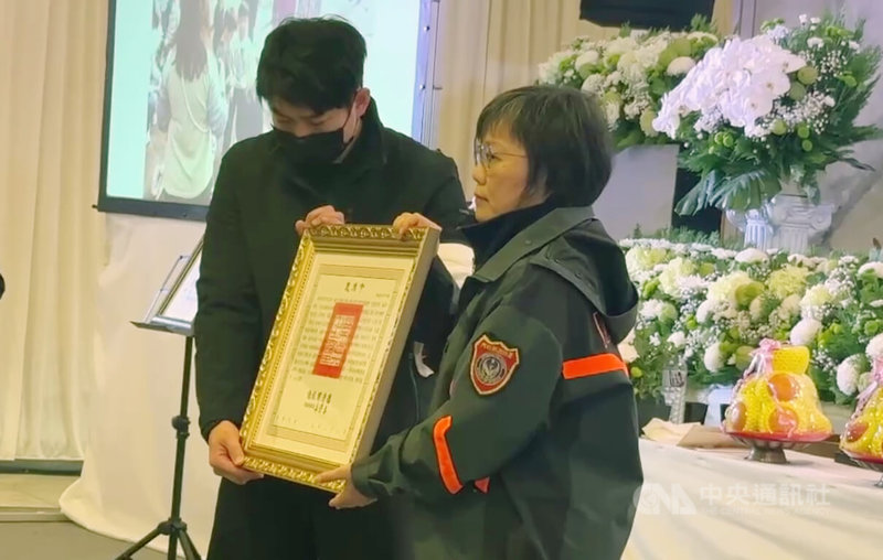 基隆市消防局仁愛消防分隊小隊長詹能傑在火場捨身救人殉職,家屬3日舉行公祭,內政部長劉世芳(右)到場追思並頒發褒揚令,由詹能傑胞弟詹庭豪(左)代表接受。中央社記者王朝鈺攝 115年2月3日
