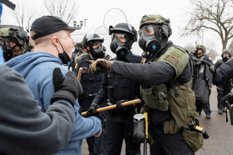 去年11月美國明尼蘇達州一名抗議者和執法人員溝通。（路透社）