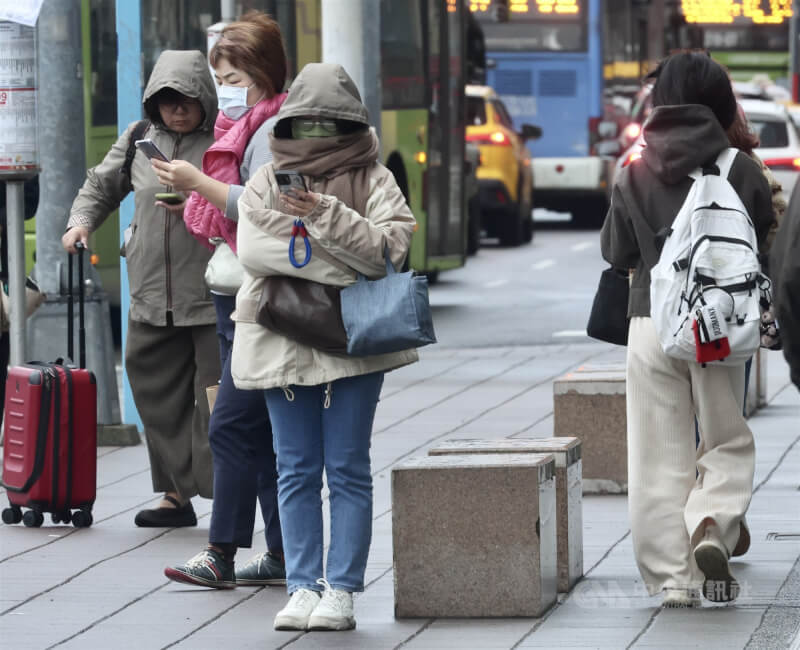 圖為台北市中正區民眾圍圍巾等公車。（中央社檔案照片）